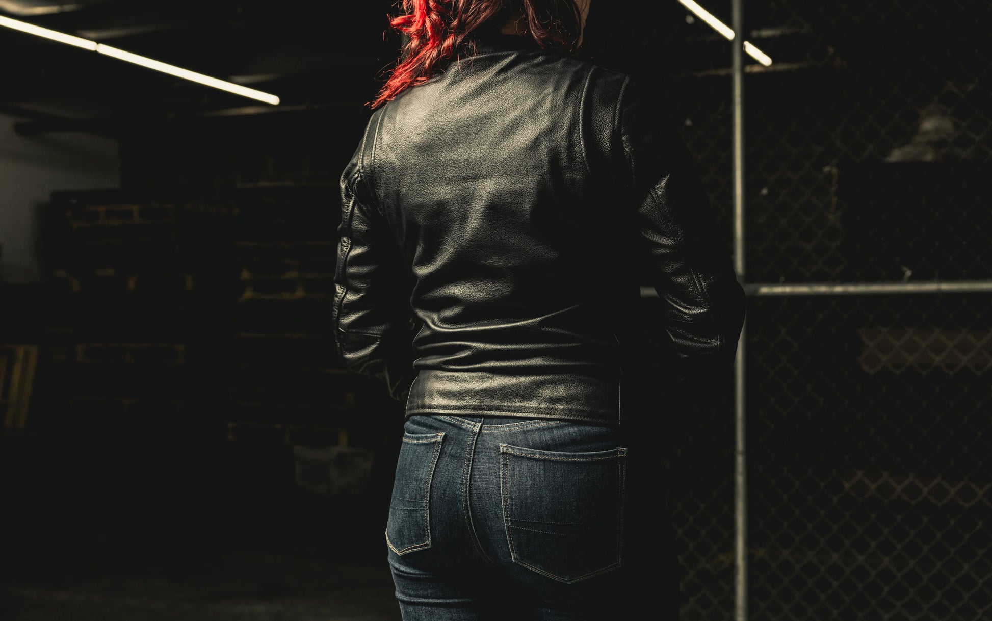  Back view of a woman wearing Flashback Leather Motorcycle Jacket, highlighting the design and silhouette from behind.