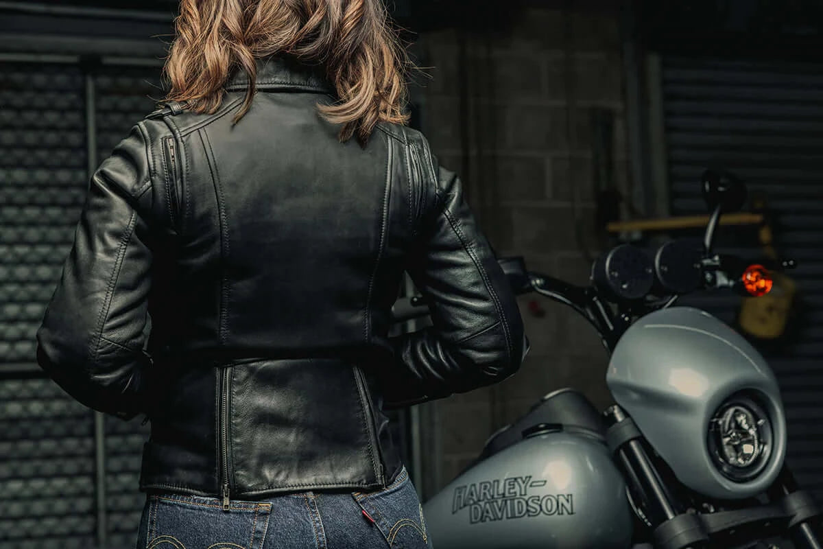  Back view of a woman wearing Bloom Women's Leather Motorcycle Jacket, showing the jacket's silhouette and design details from behind.